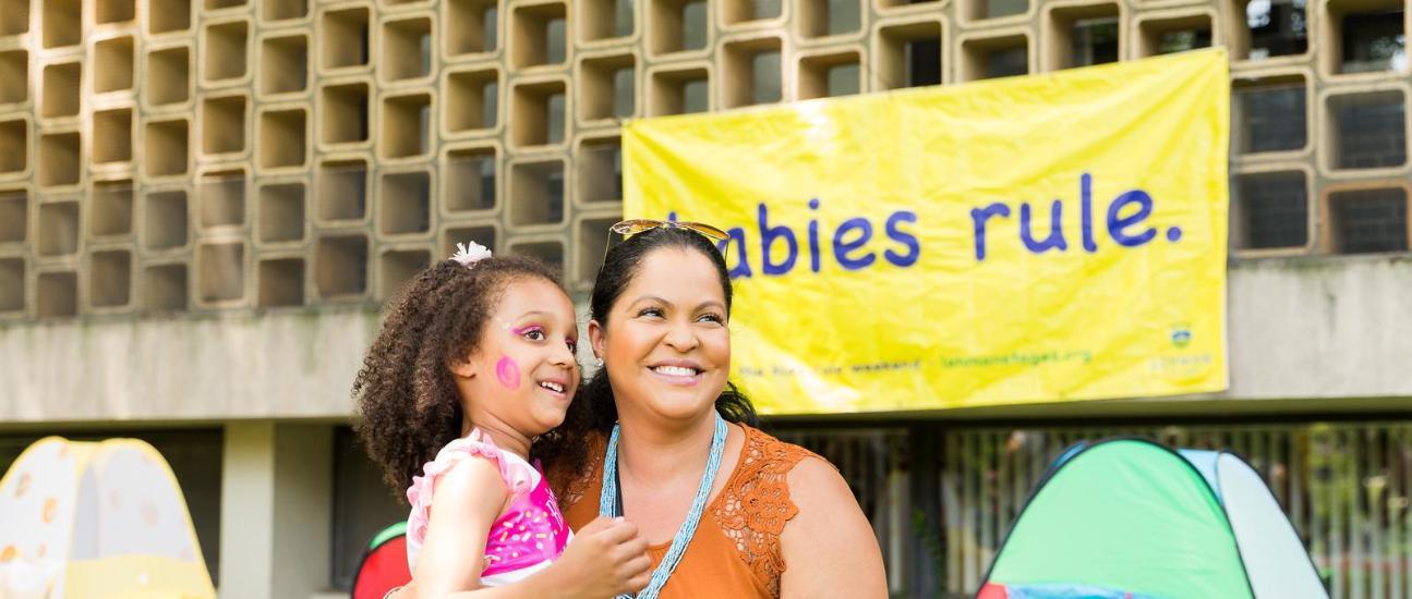 Child with Adult in from of Babies Rule Sign