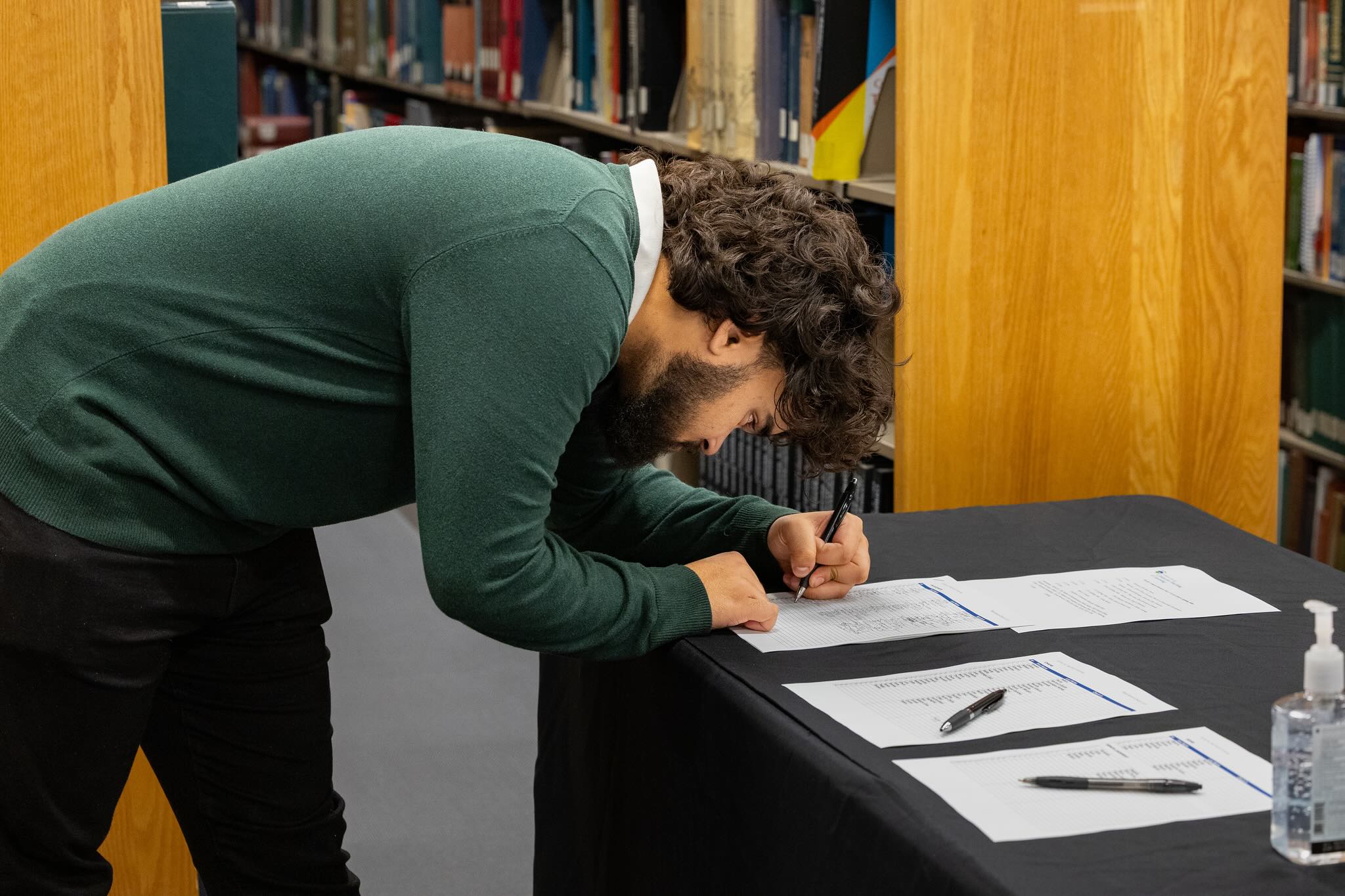 student signing up with pen to paper.