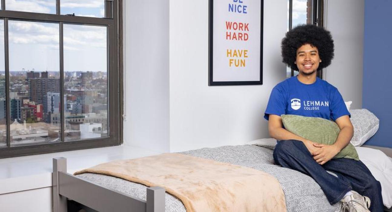 Student sitting on the bed in dorm 