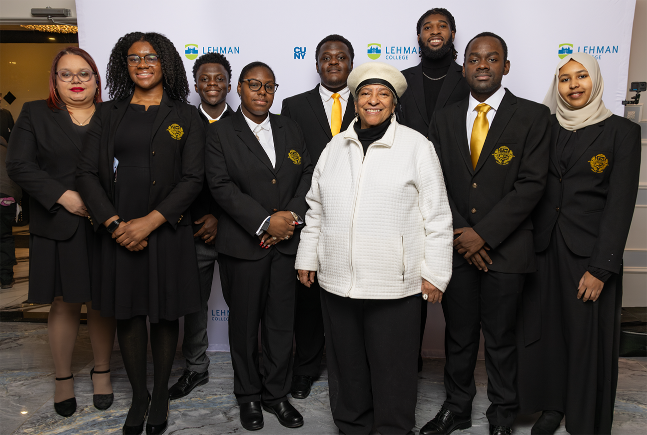 Members of the Urban Male Leadership Program pose for a group photo in formal black and gold attire at a gala or ceremony.