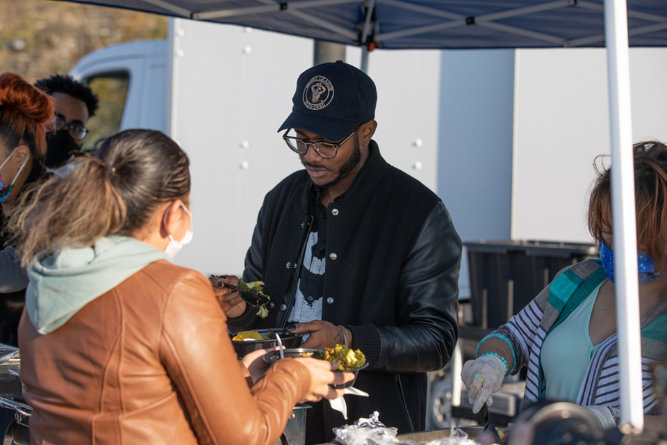 Chef Kwame Onwuachi and a Lehman student at the Buen Provecho Thanksgiving food giveaway.