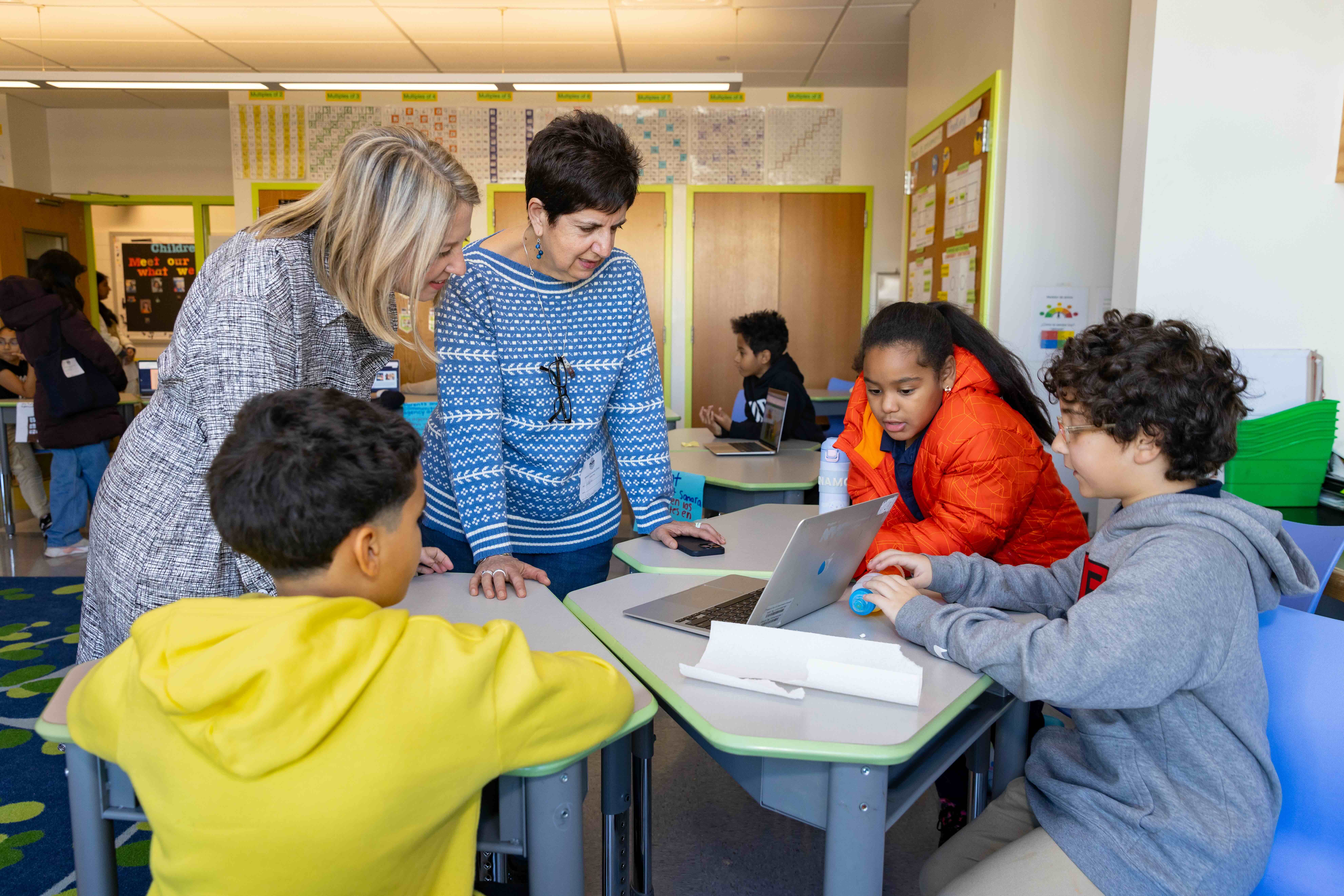 Assoc. Professor Tiffany DeJaynes (left) and Cecilia Espinosa, chair of Early Childhood/Childhood Education, with children from Samara Community School, a leader in multilingual education. 