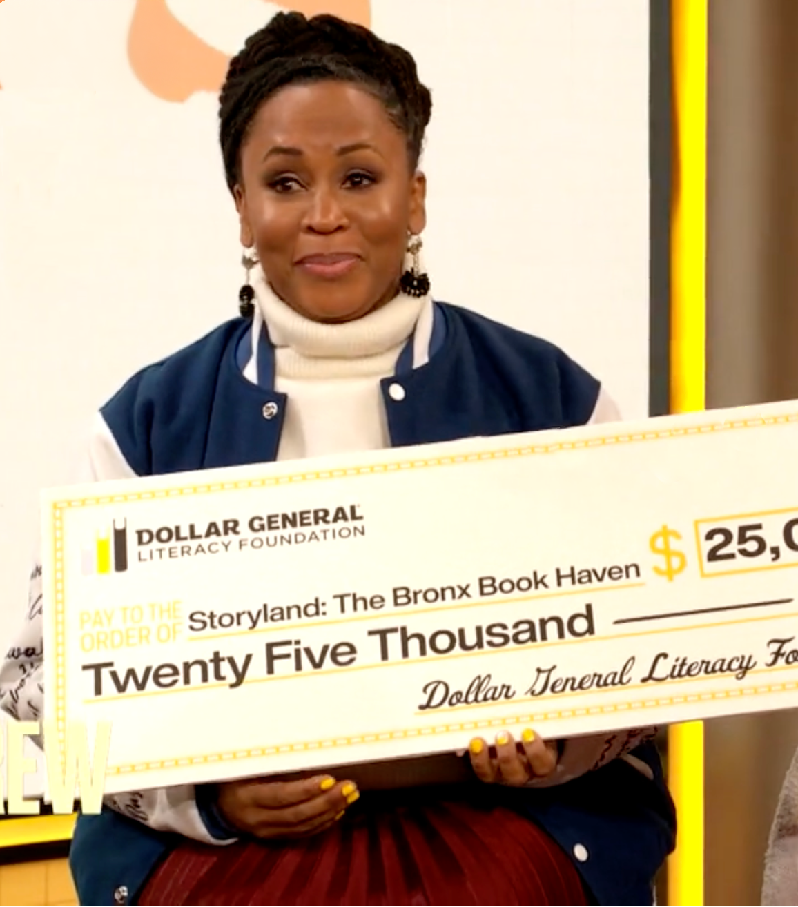 Sulma Arzu-Brown holding a giant check for $25,000