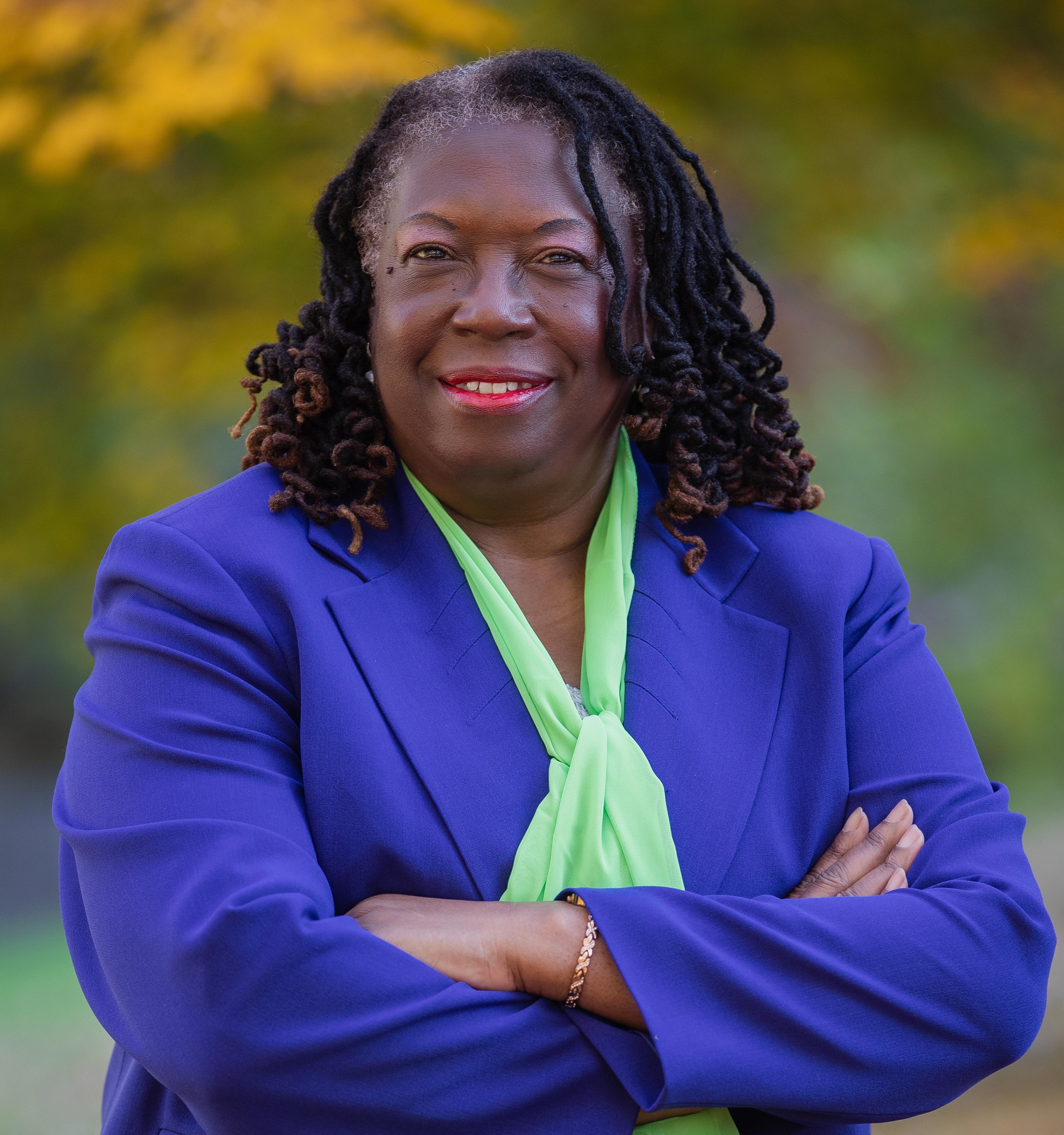 Dean Elgloria Harrison, dressed in green and blue.