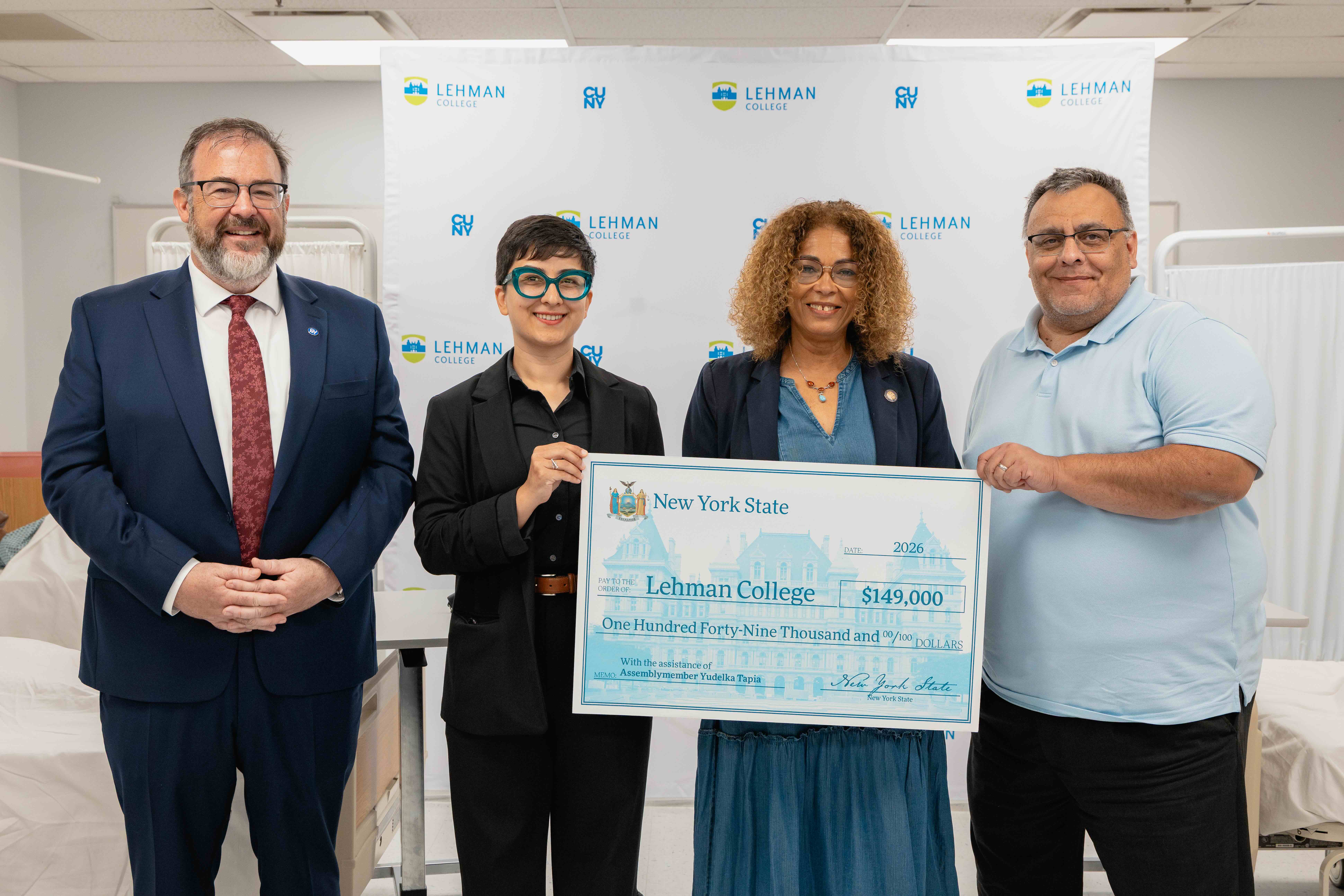 Dermot Smyth, Azadeh Keivani, Yudelka Tapia, and Fernand Delgado. Tapia holds a large presentation check.