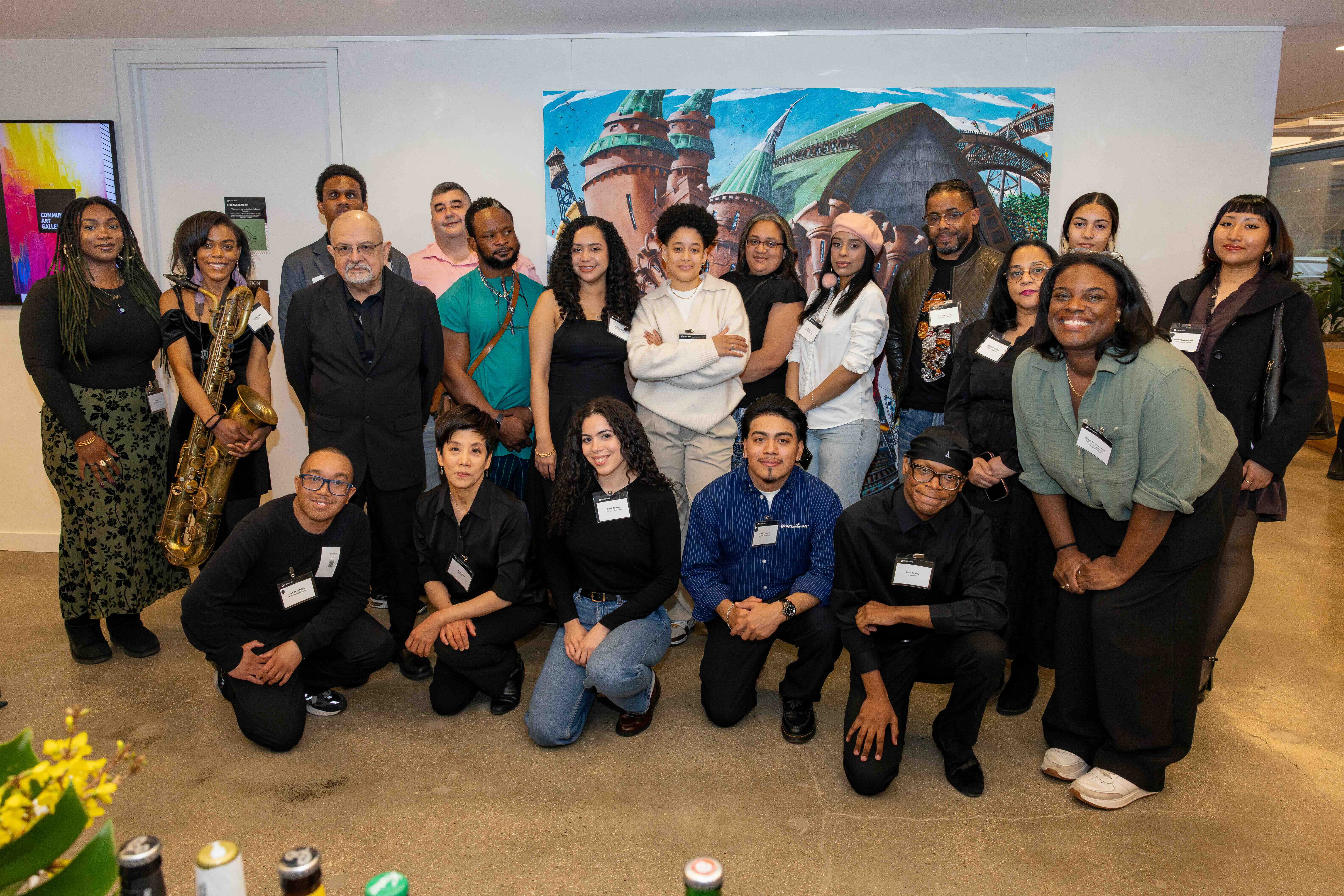 A group of student artists, musicians, and the Deputy Manhattan Borough President pose in front of a painting.