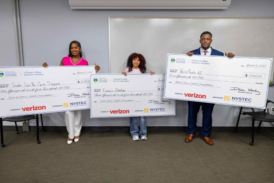 Three winners of the pitch contest hold their presentation checks.