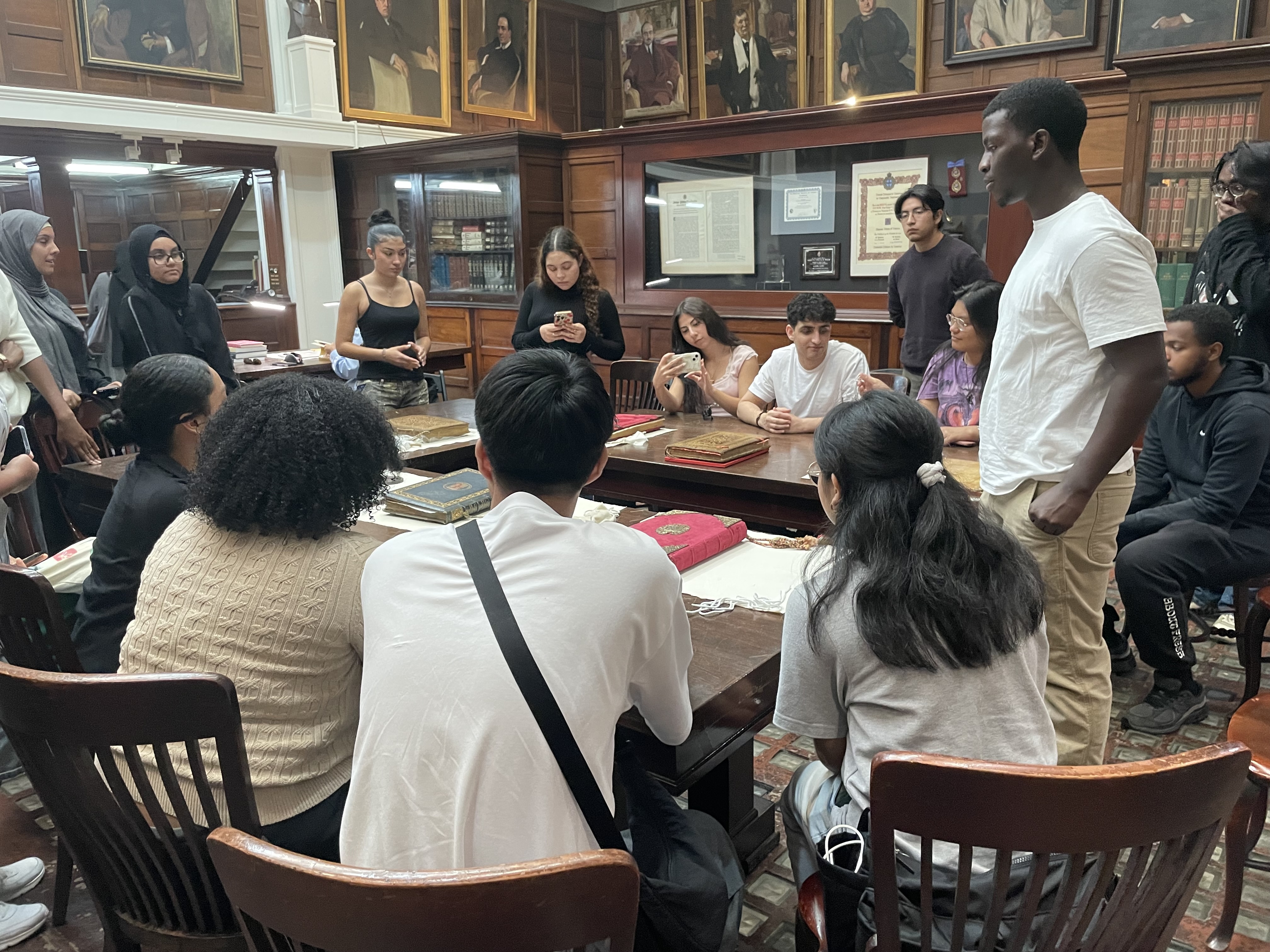 A group of students around a large table in a library
