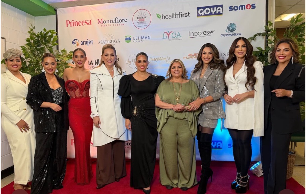 A group of women in formal dress pose at an event.