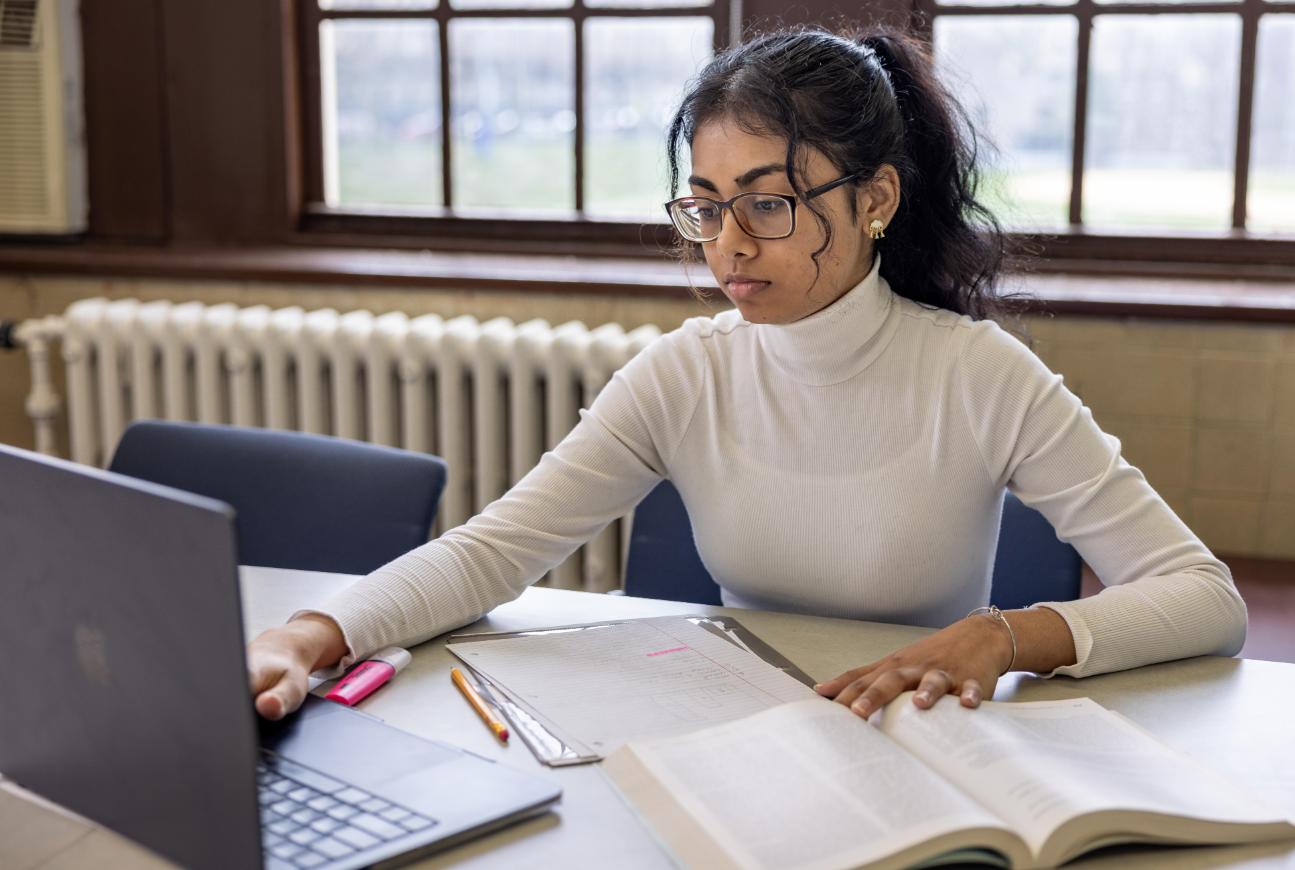 A student sitting at a computer taking classes online