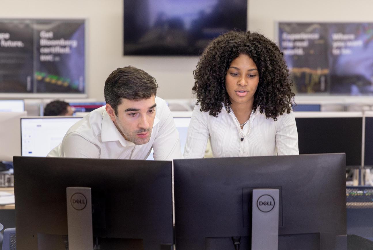 Students in front of computers looking through numbers