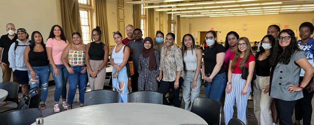 Students in front of table smiling