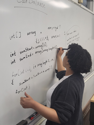 Student writing an algorithm for a whiteboard coding session